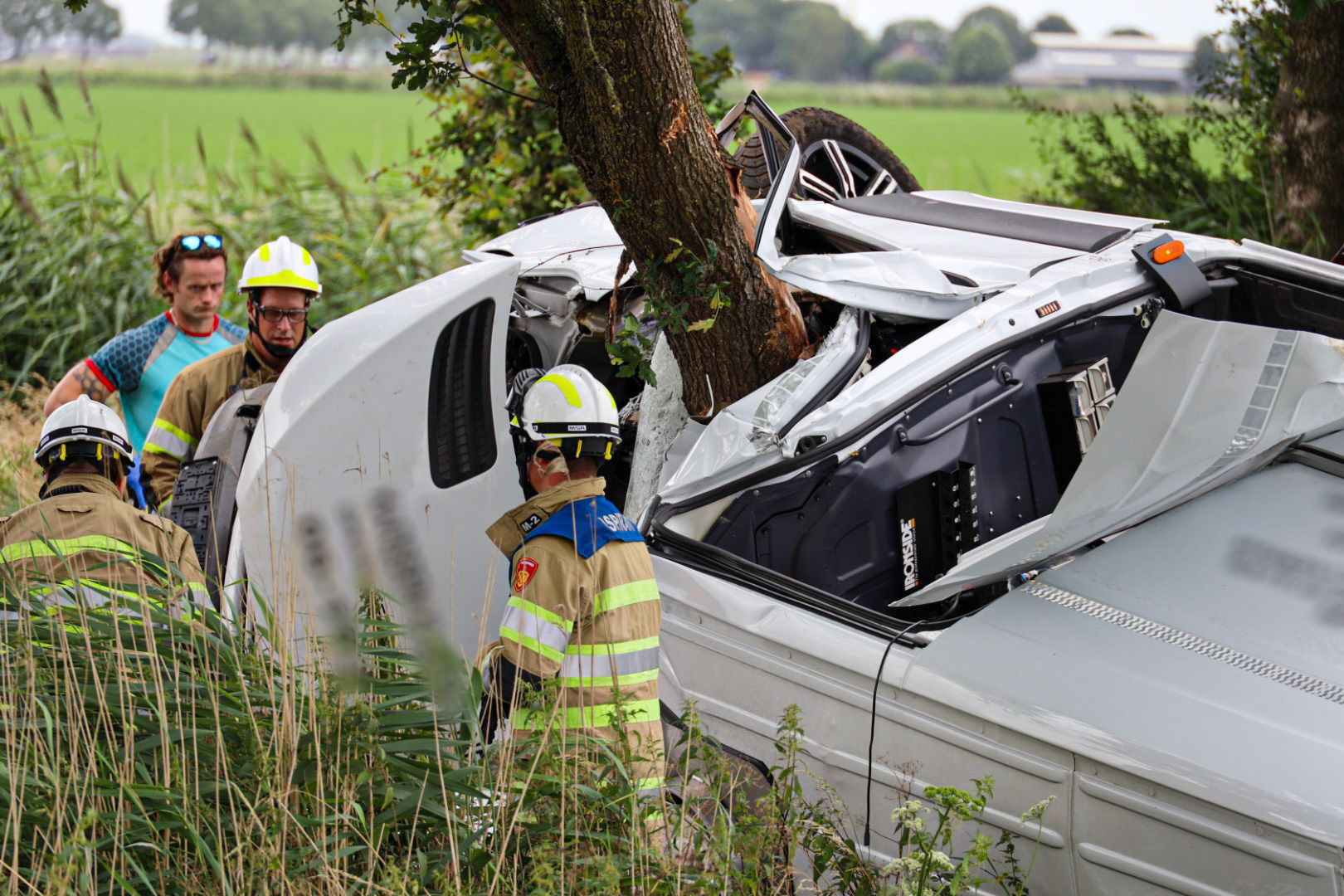 Bestuurder dood na crash, werkbus om boom heen gevouwen
