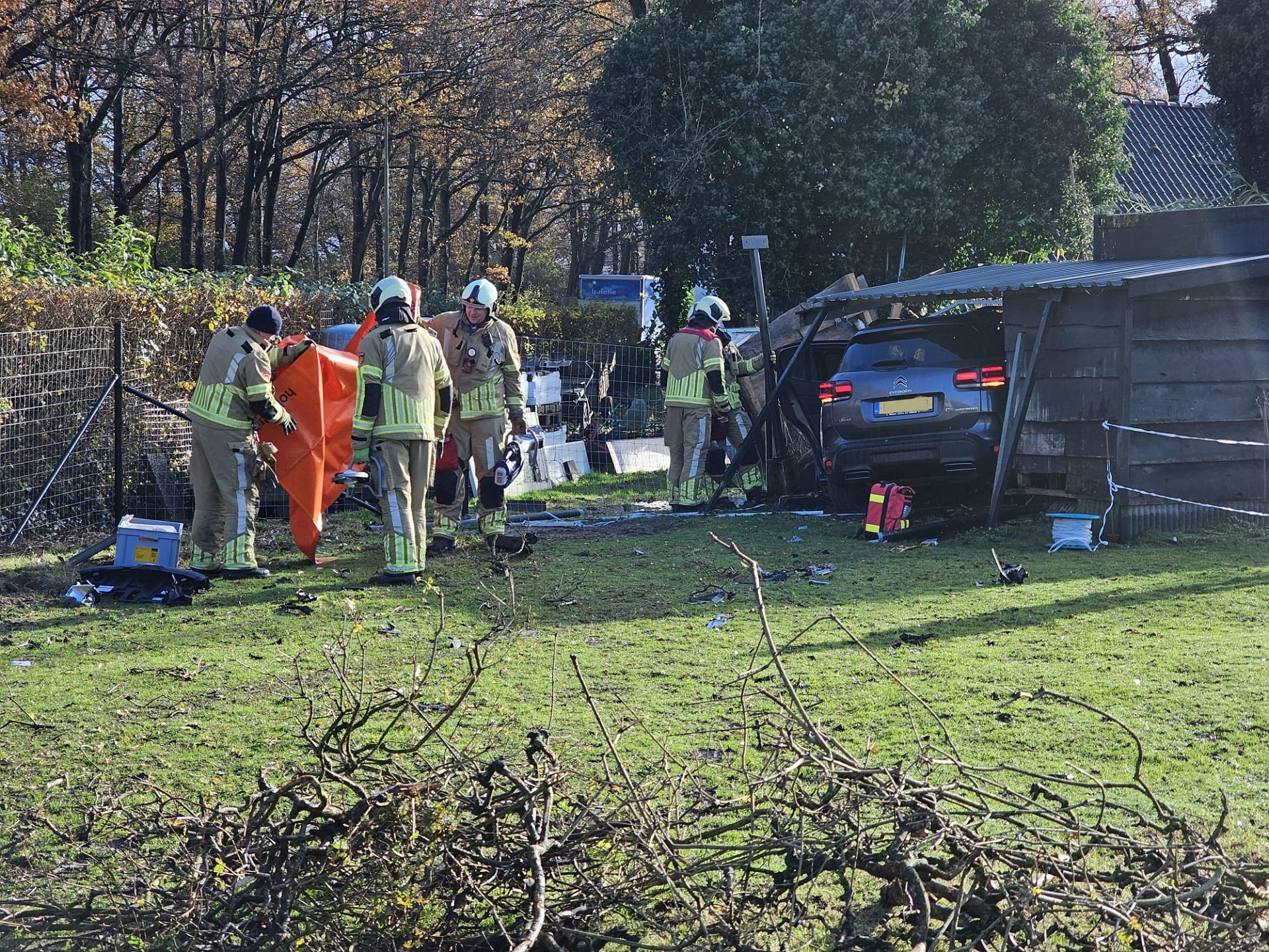 Auto belandt in tuinhuis na ongeval, drie gewonden