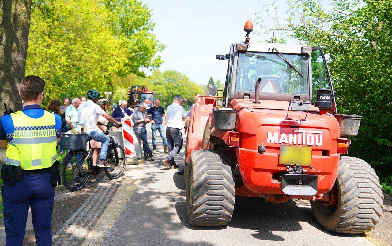 Tractoren blokkeren de weg na plaatsing betonblokken door gemeente