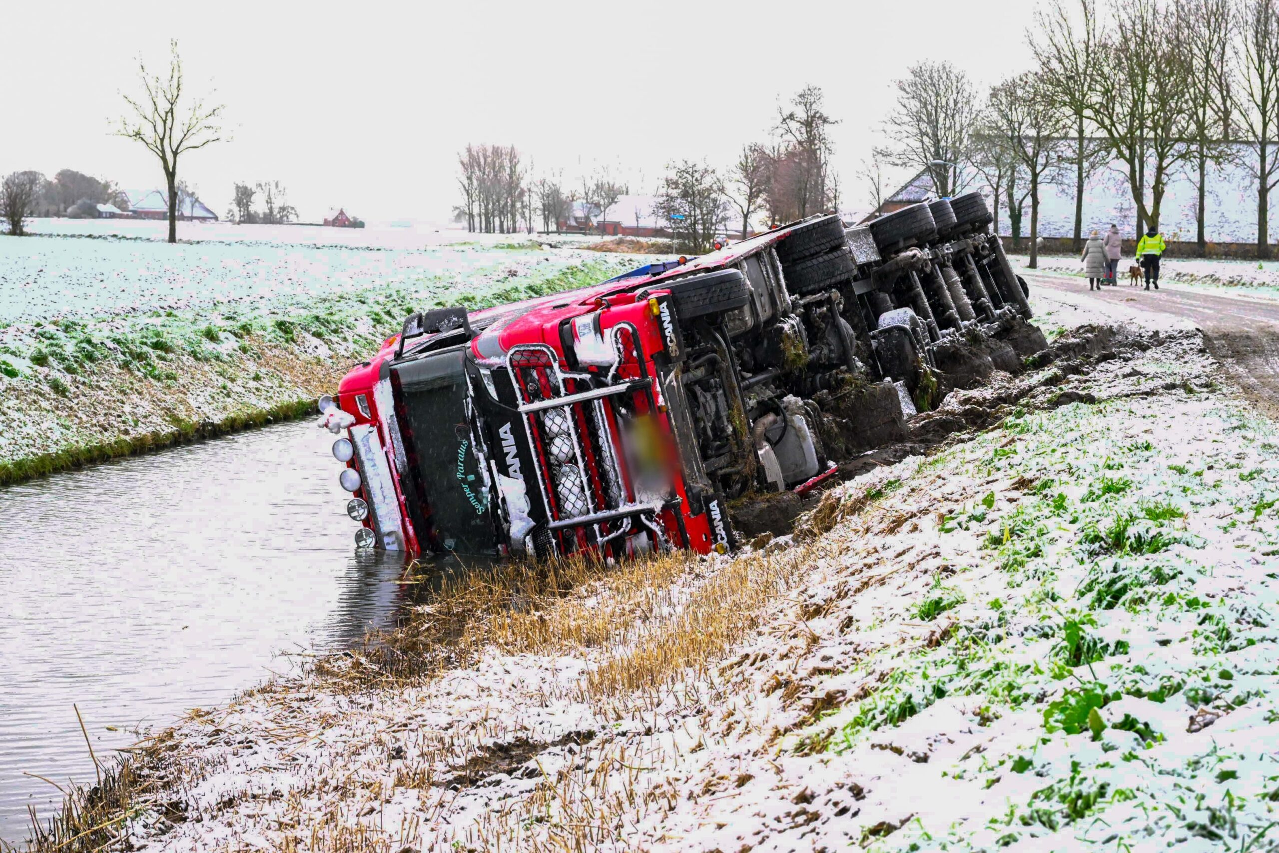 Vrachtwagen kantelt en belandt in sloot tijdens sneeuwbui