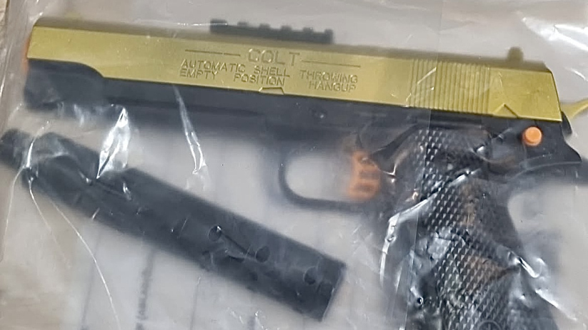 Persoon zwaait met gelblaster uit het raam