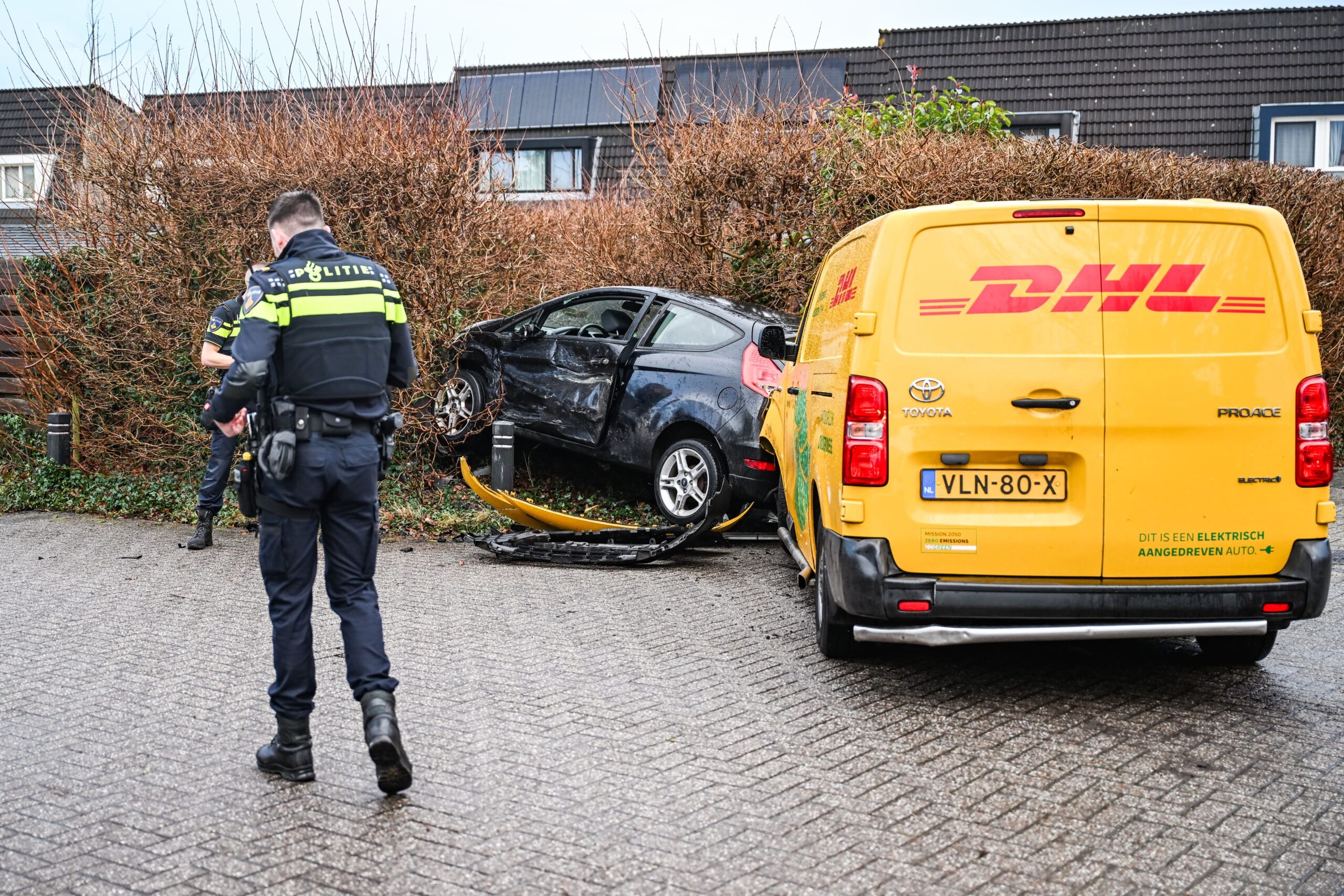 Auto belandt in tuin na aanrijding met DHL-busje