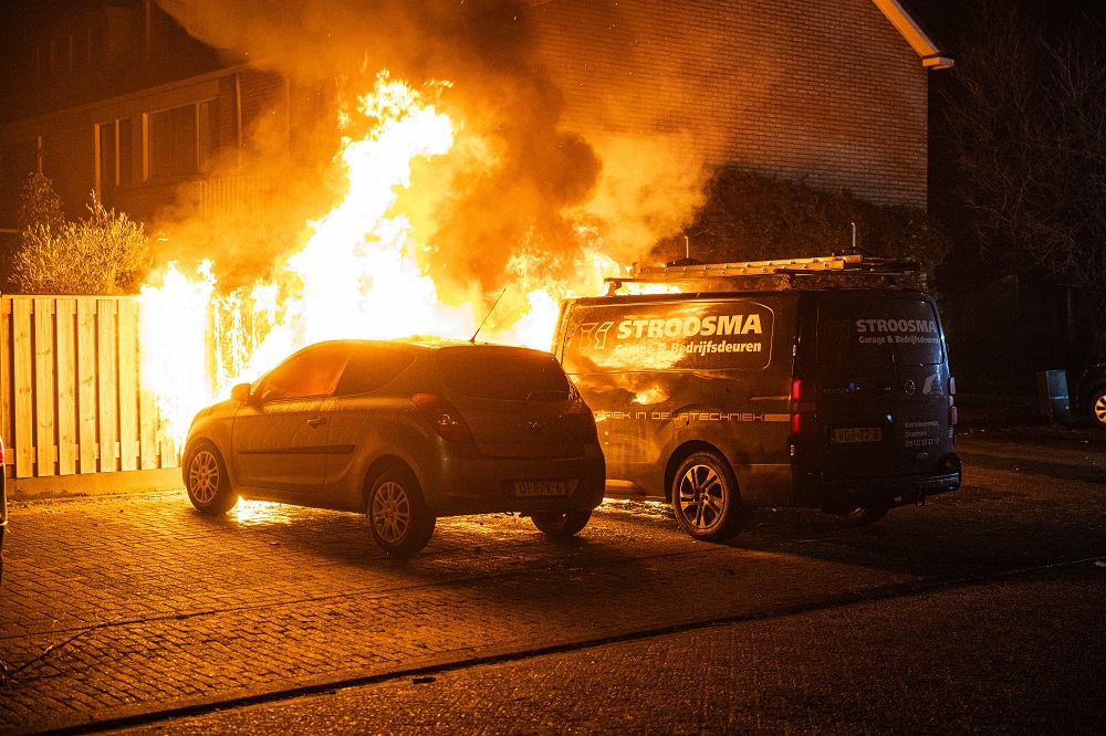 Bestelbus, auto en schutting in brand, mogelijk brandstichting