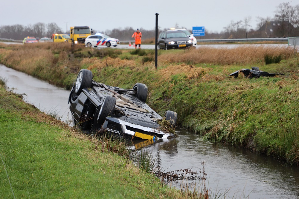 Auto op z’n kop in sloot, hulpdiensten massaal opgeroepen