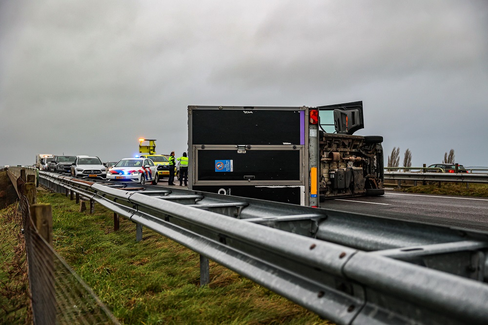 Bestelbus met aanhanger gekanteld door harde wind