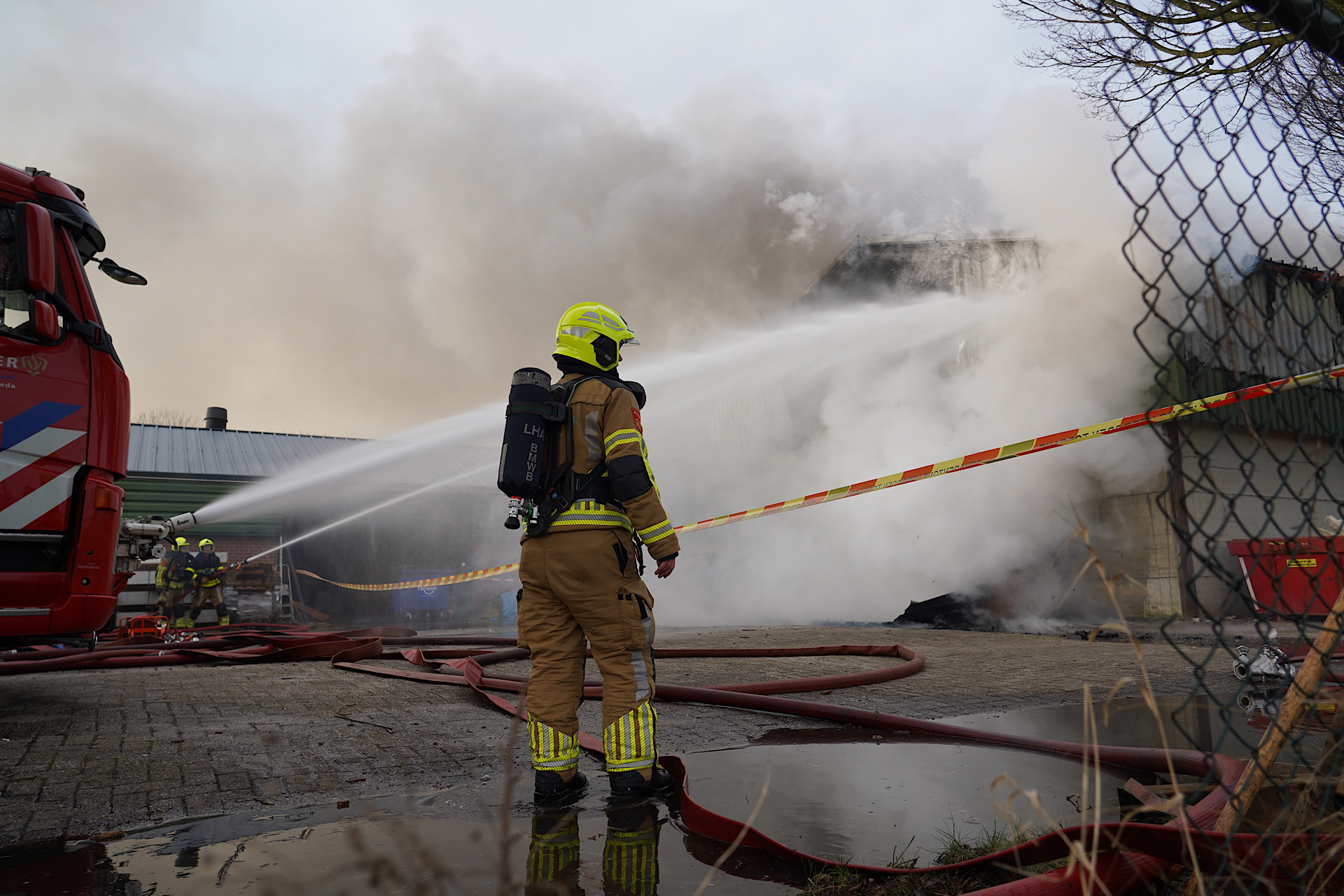 Loods in brand in buitengebied, rookpluim van grote afstand zichtbaar