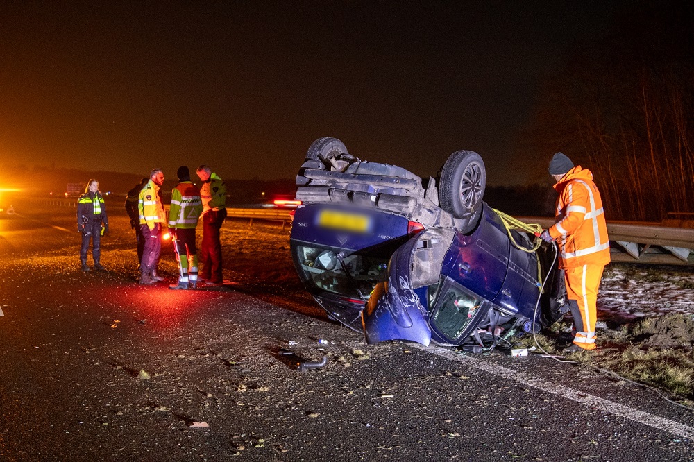 Auto over de kop op snelweg, twee inzittenden gewond