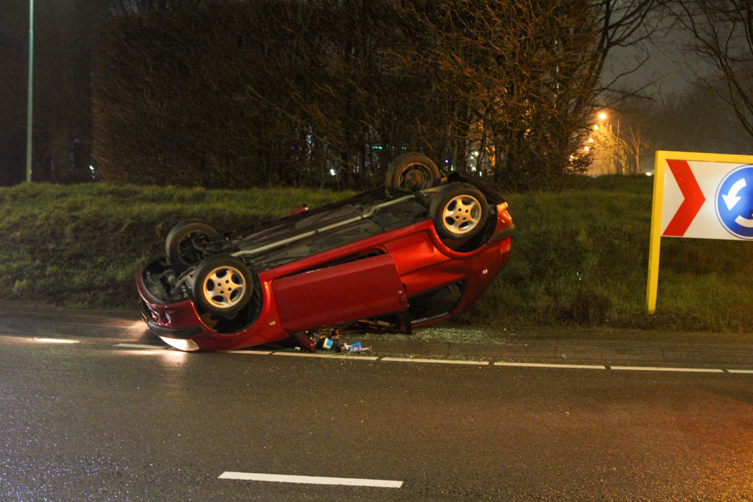 Auto met vier inzittenden slaat over de kop op rotonde