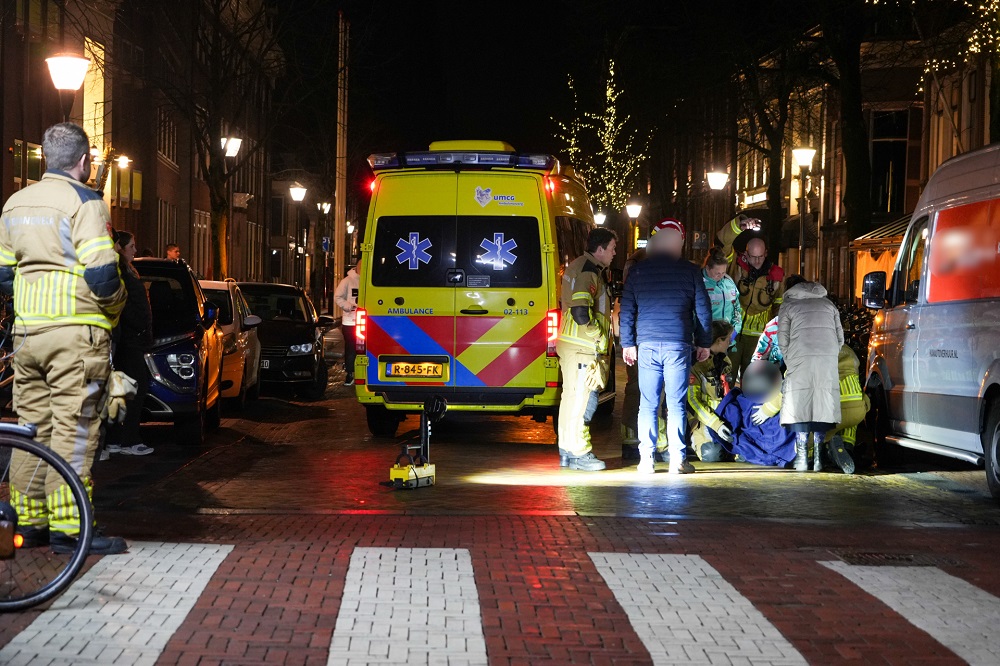 Vrouw bekneld onder bestelbus