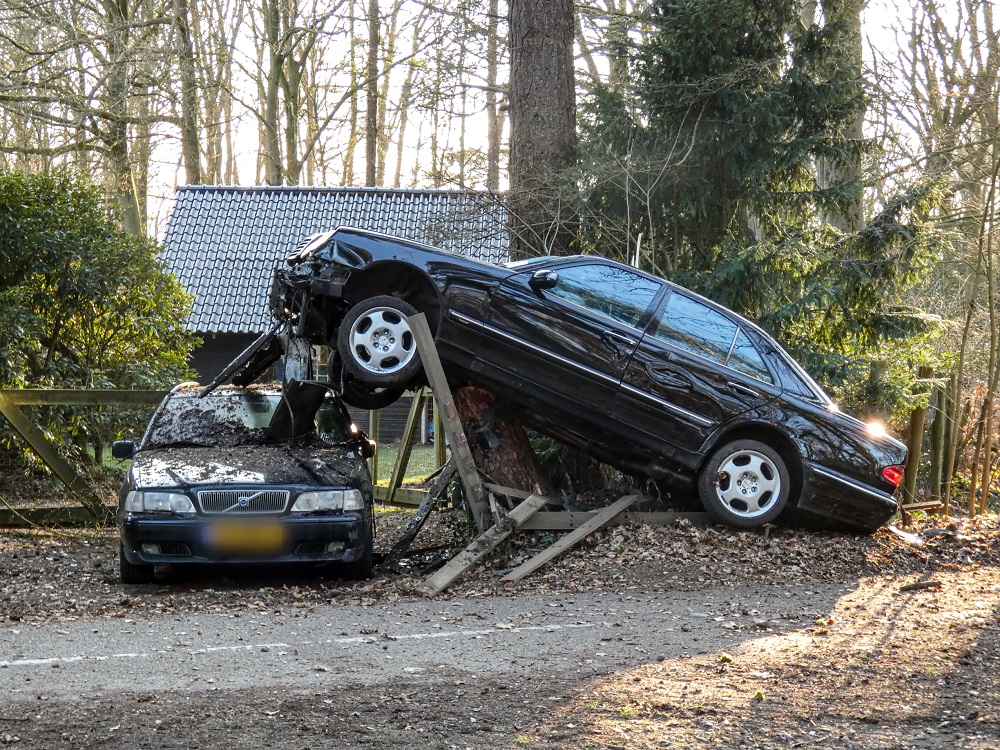 Auto vliegt uit de bocht en eindigt boven op boomstronk