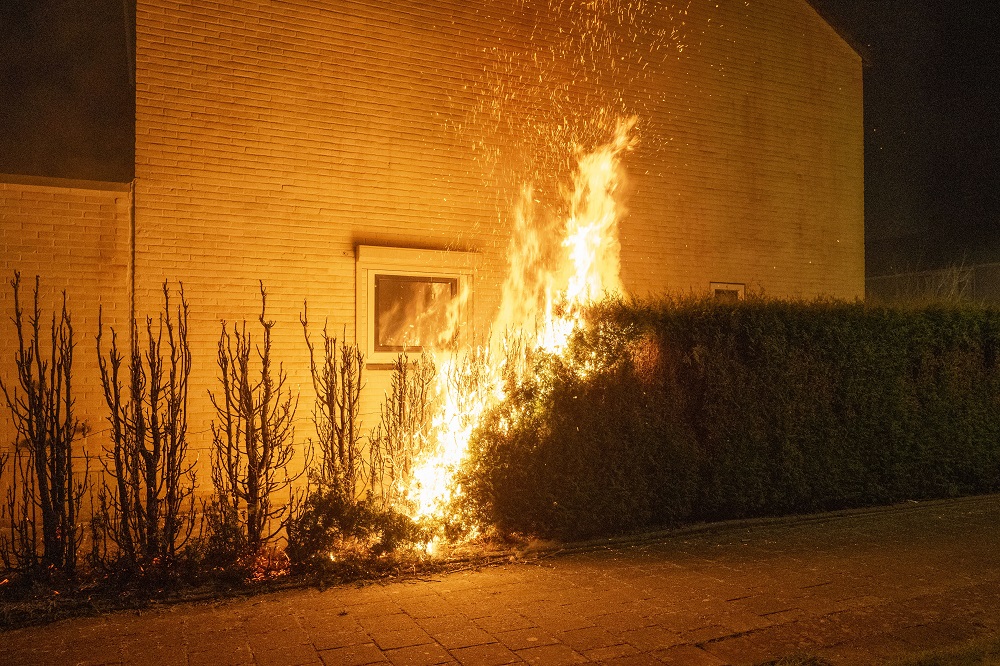 Coniferenhagen in brand gestoken, politiewagen bekogeld met steen
