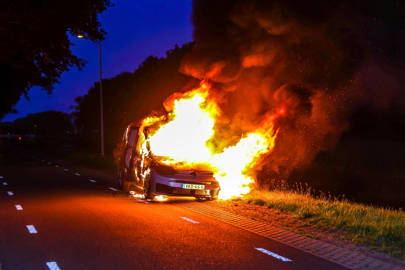 Brandweer blust auto die in brand vliegt