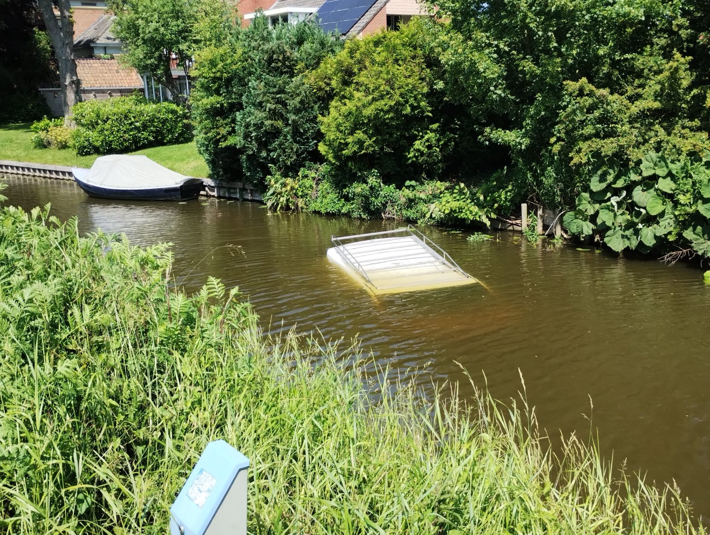 Vermoedelijk handrem vergeten, busje belandt in het water