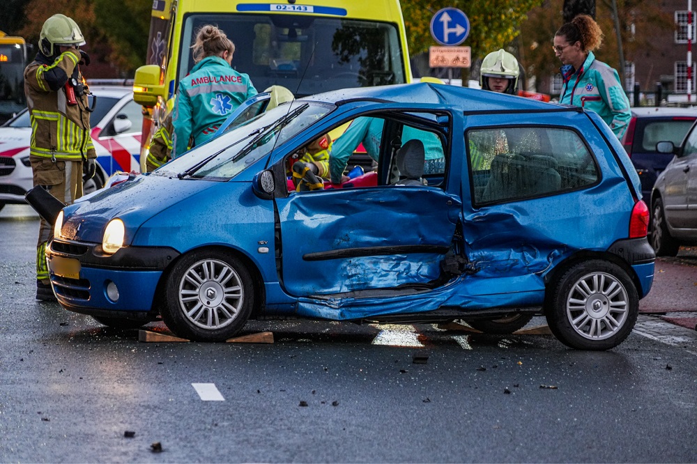 Automobilist bekneld in auto na ongeval op kruising