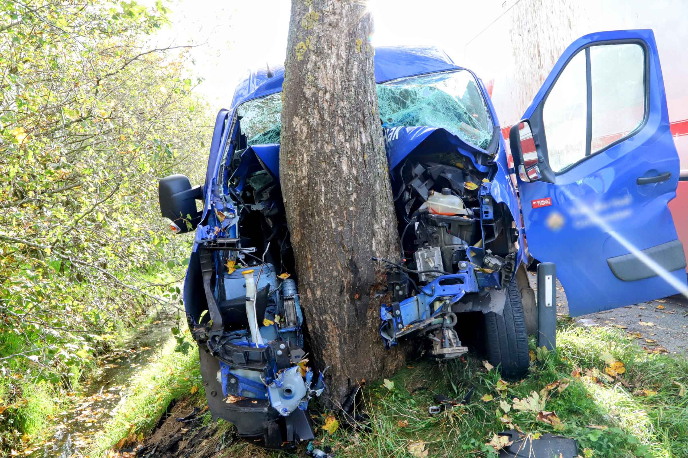 Bestelbus crasht tegen boom en raakt bekneld