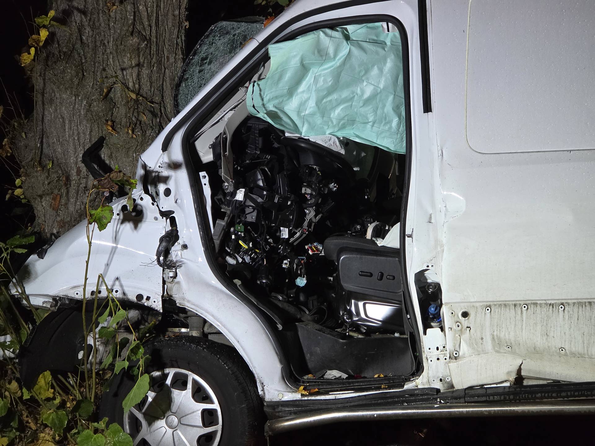 Bestuurder bekneld na botsing van bestelbus tegen boom