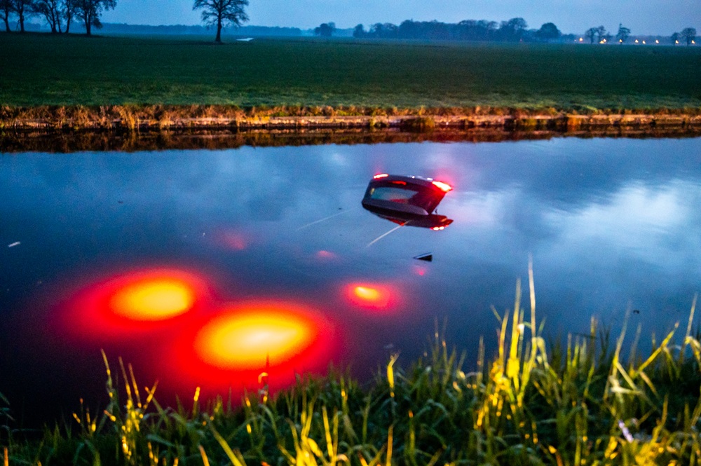 Auto raakt van de weg en belandt in water, bestuurder gewond