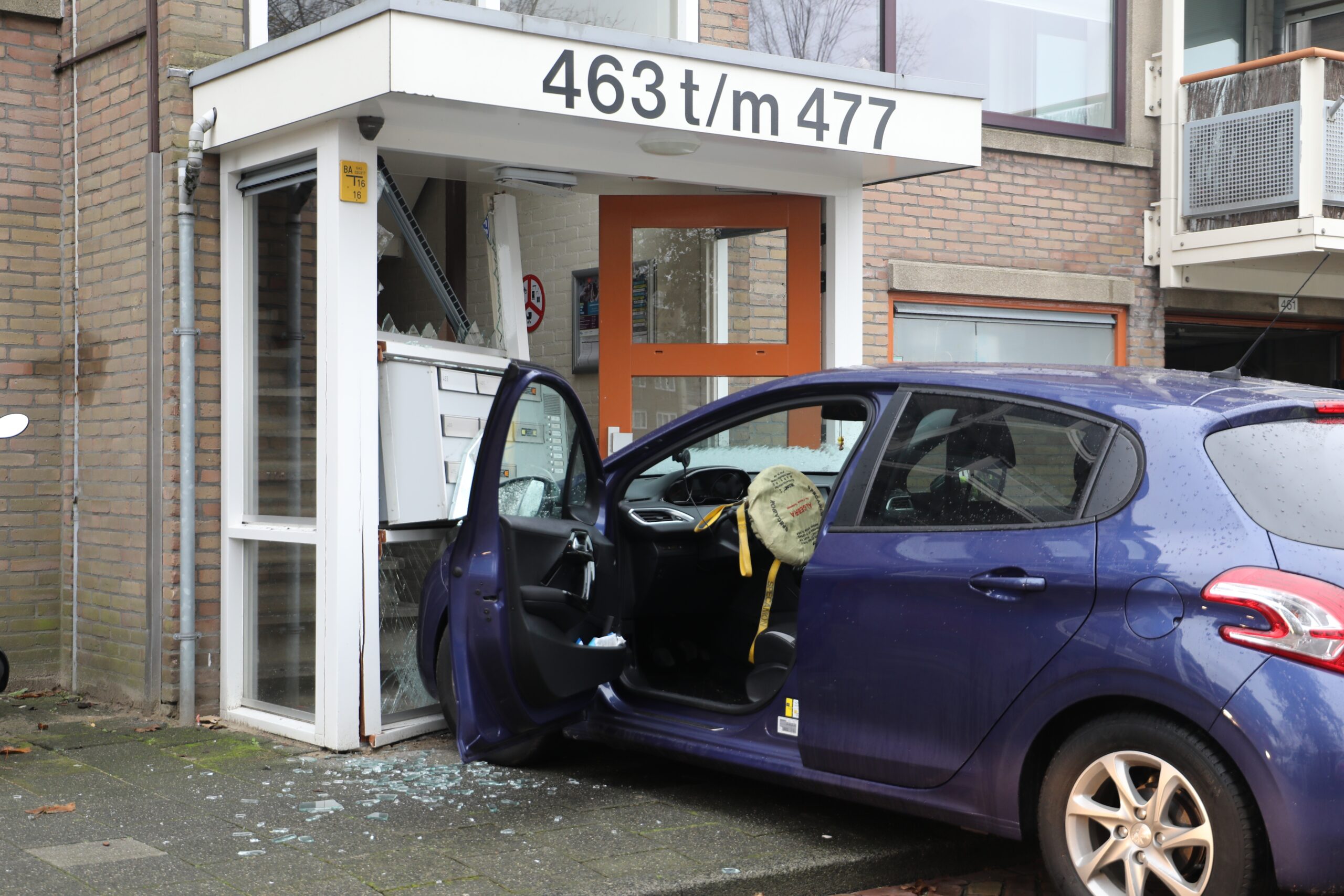 Automobilist ramt portiek van appartementencomplex