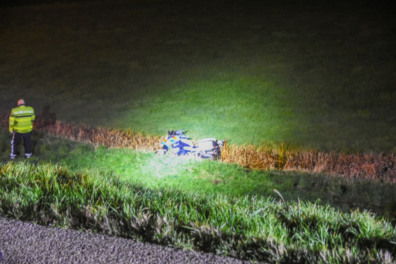 Twee motoragenten rijden van dijk af de sloot in