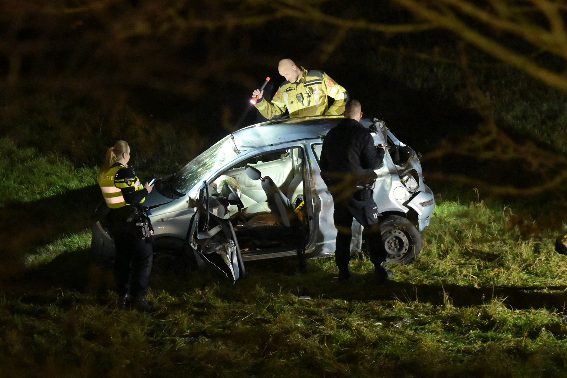 Auto crasht en rijdt van talud, bestuurder gewond
