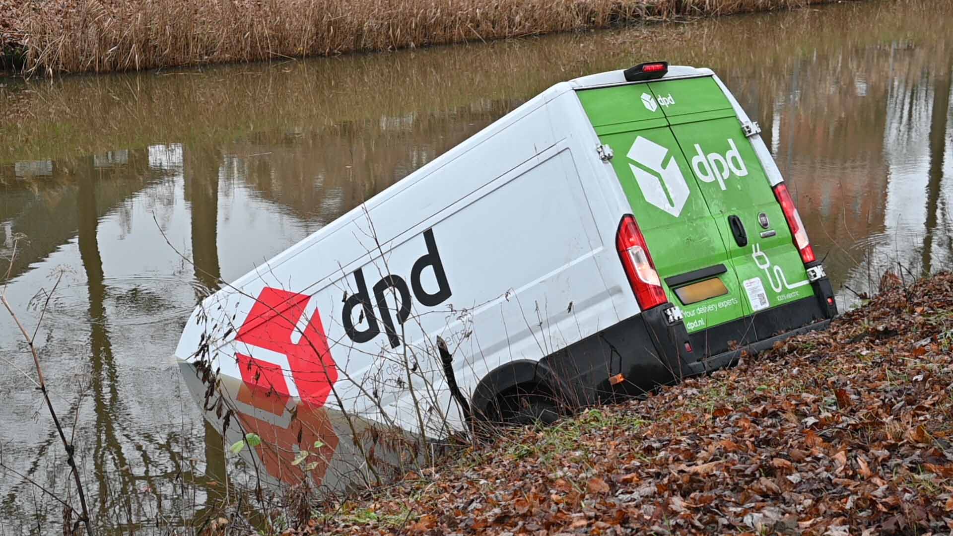 Bus van pakketbezorger rolt het water in