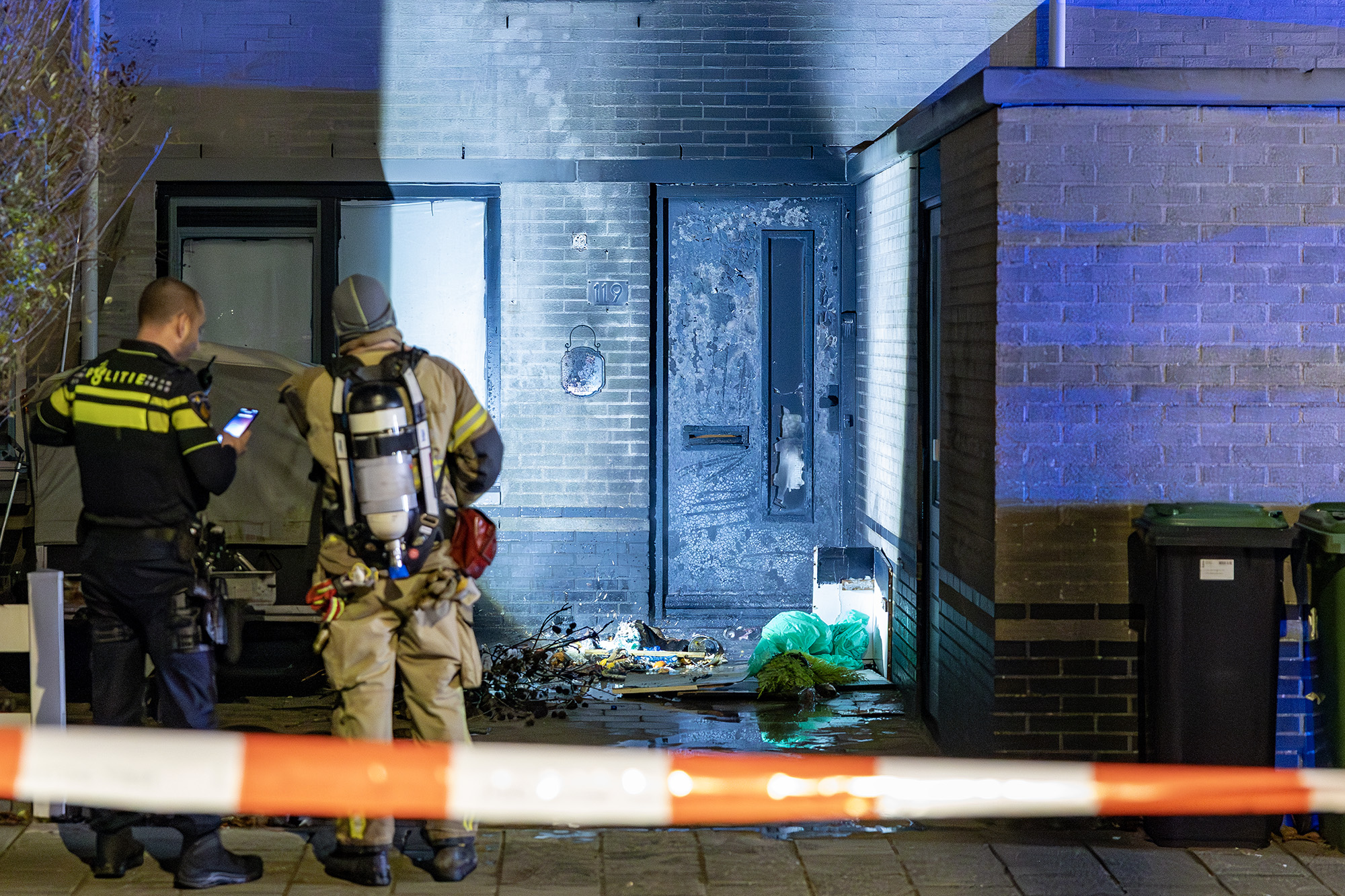 Voordeur van woning in brand, mogelijk door explosie