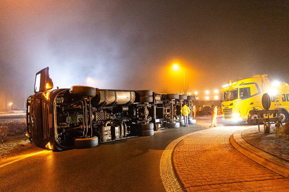 Vrachtwagen kantelt op rotonde, chauffeur gewond