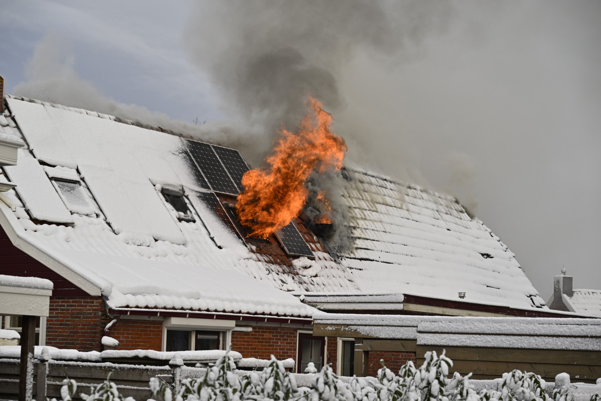 Vlammen slaan uit dak bij zolderbrand