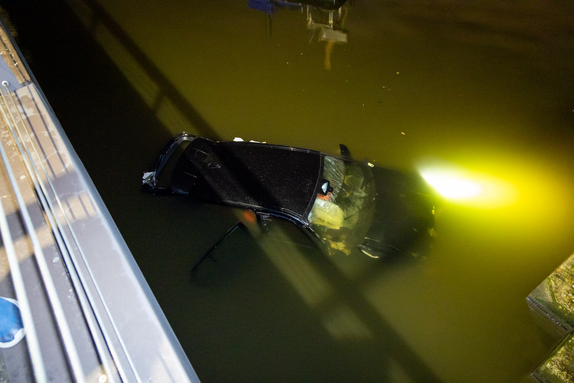 Auto crasht en rijdt van brug, bestuurder uit water gered