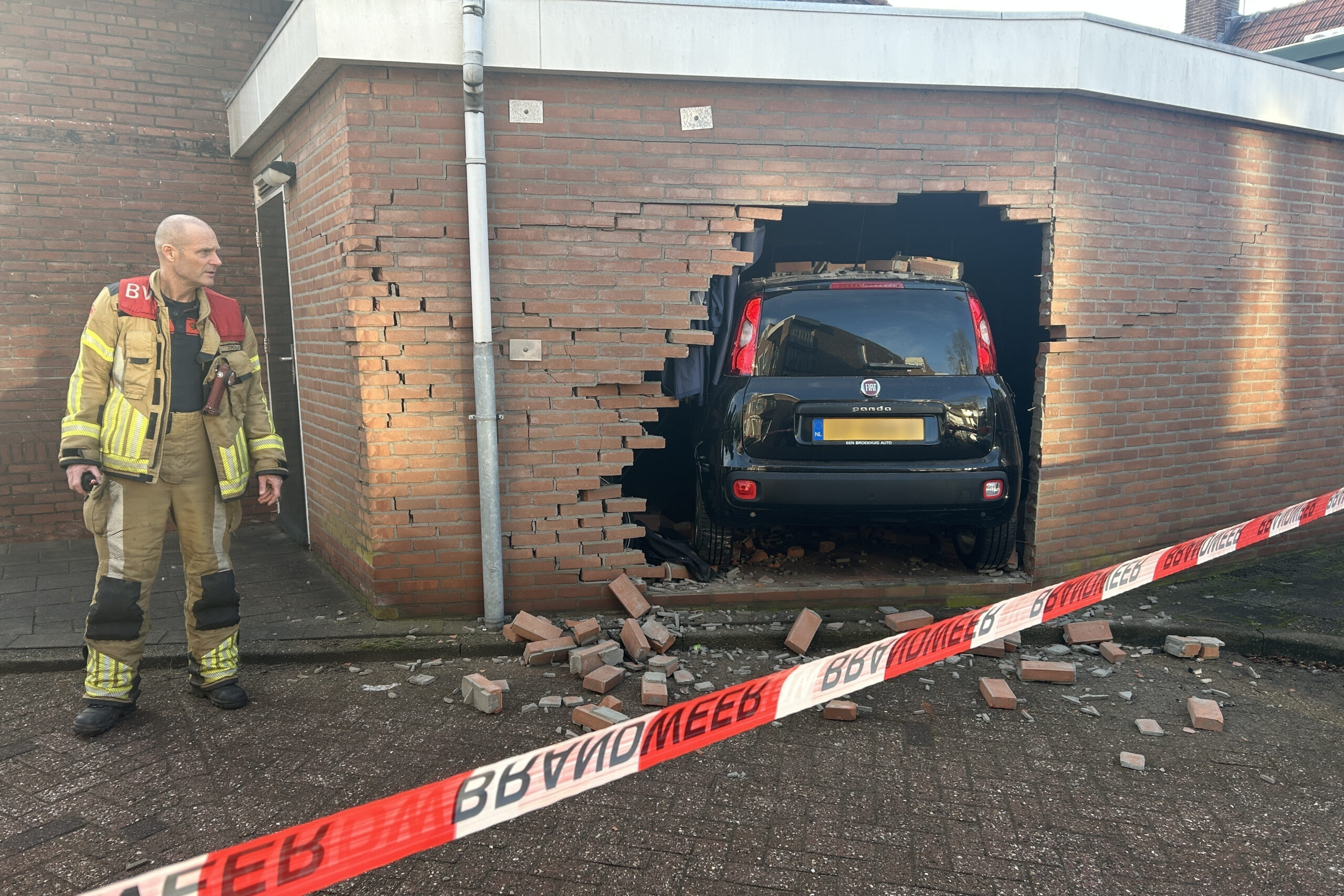 Vrouw rijdt dwars door muur van schuur heen