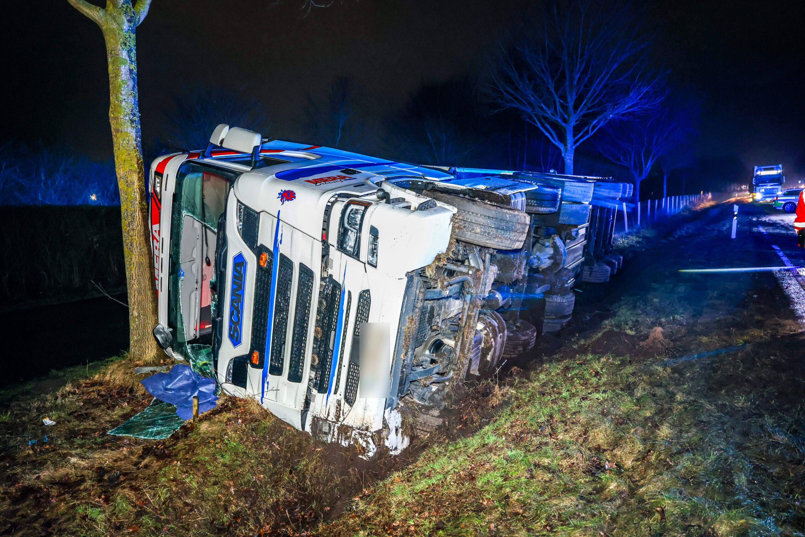 Vrachtwagen kantelt over grens, chauffeur naar ziekenhuis