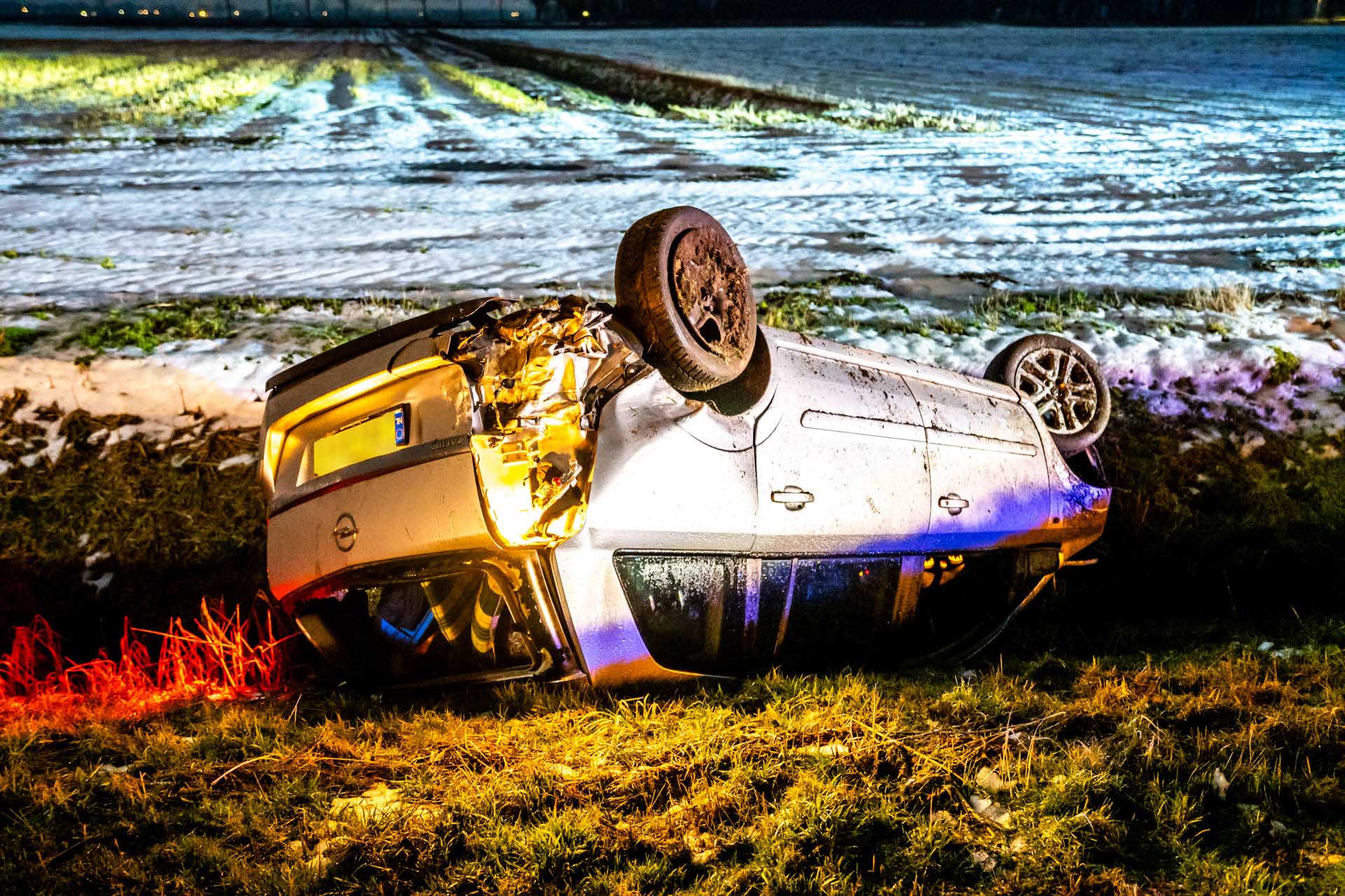 Voertuig belandt op de kop na botsing op spekgladde weg