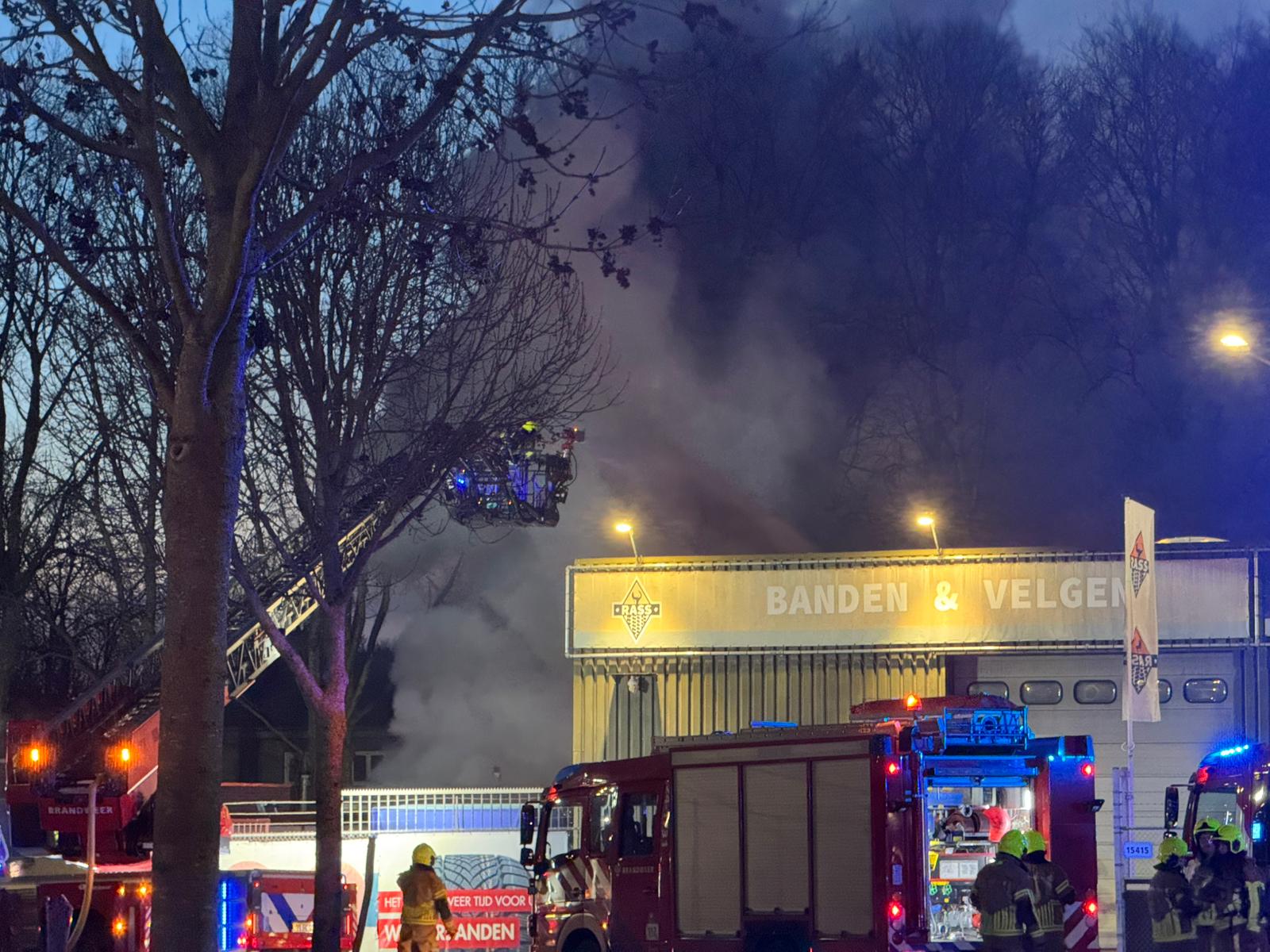 Grote uitslaande brand bij bandenbedrijf