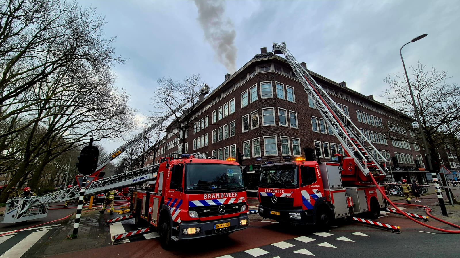 Grote brand op dak van portiekwoningen