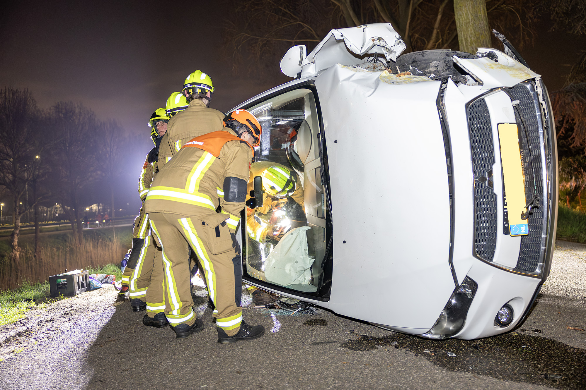 Auto belandt op z’n kant na botsing tegen boom