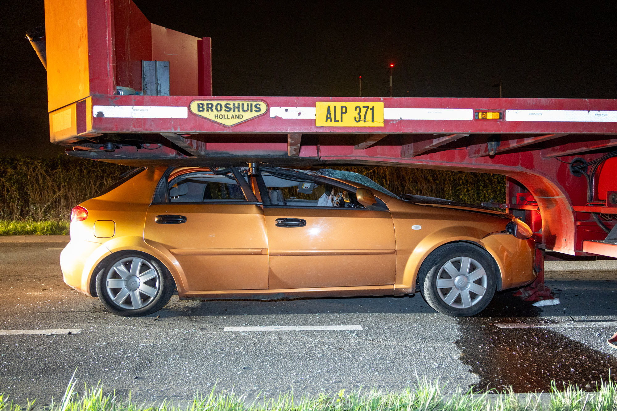 Auto rijdt onder geparkeerde trailer, bestuurder gewond