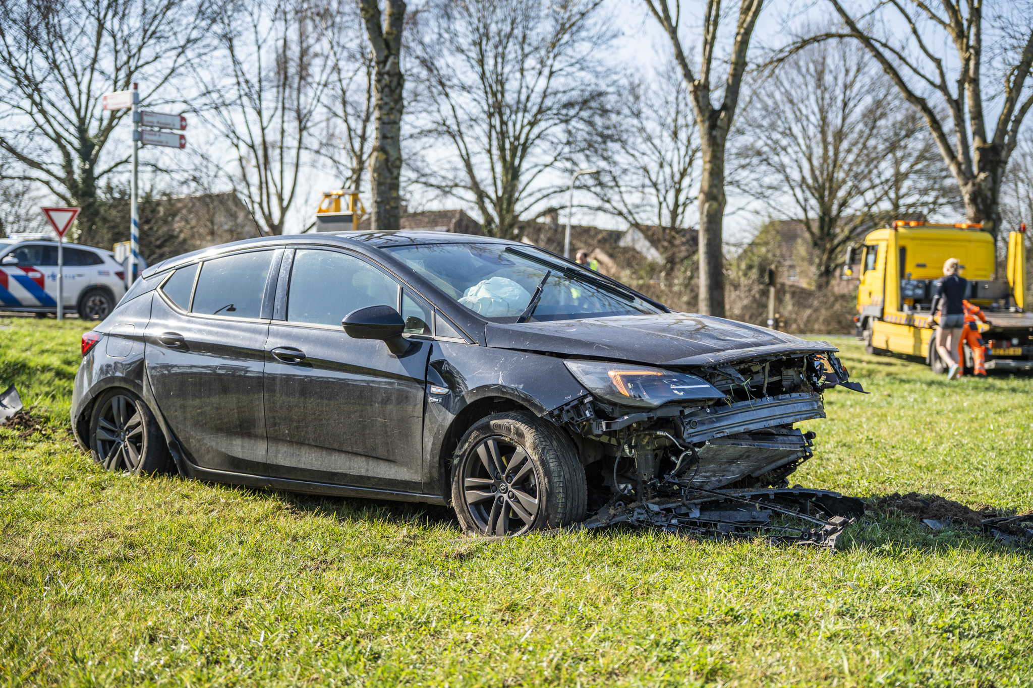 Auto raakt van rotonde en belandt in weiland