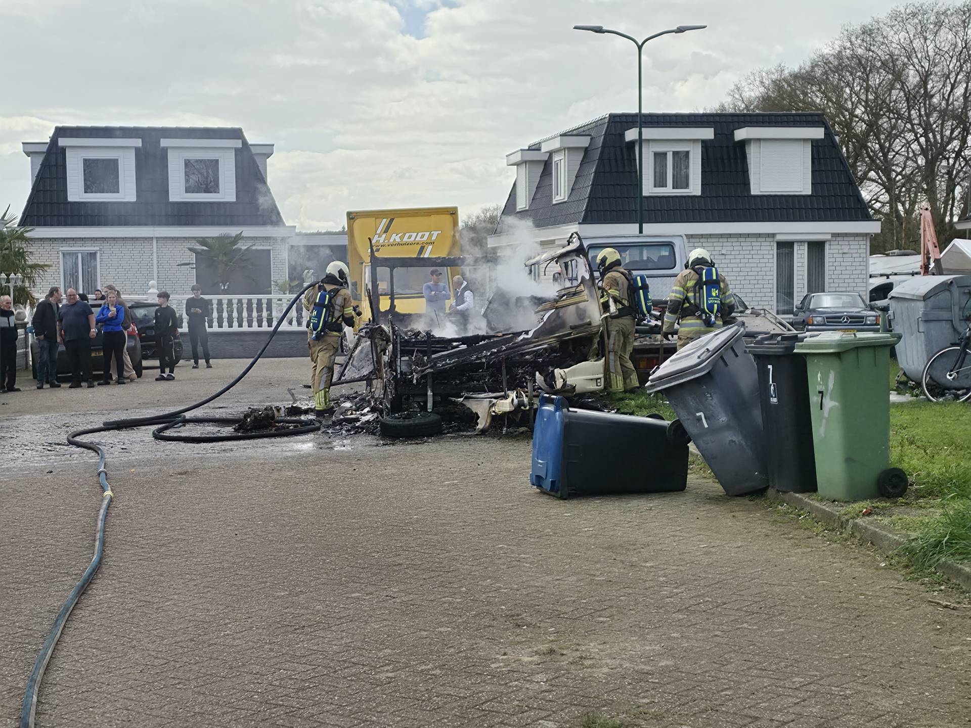 Caravan verwoest door brand, rook in verre omgeving te zien