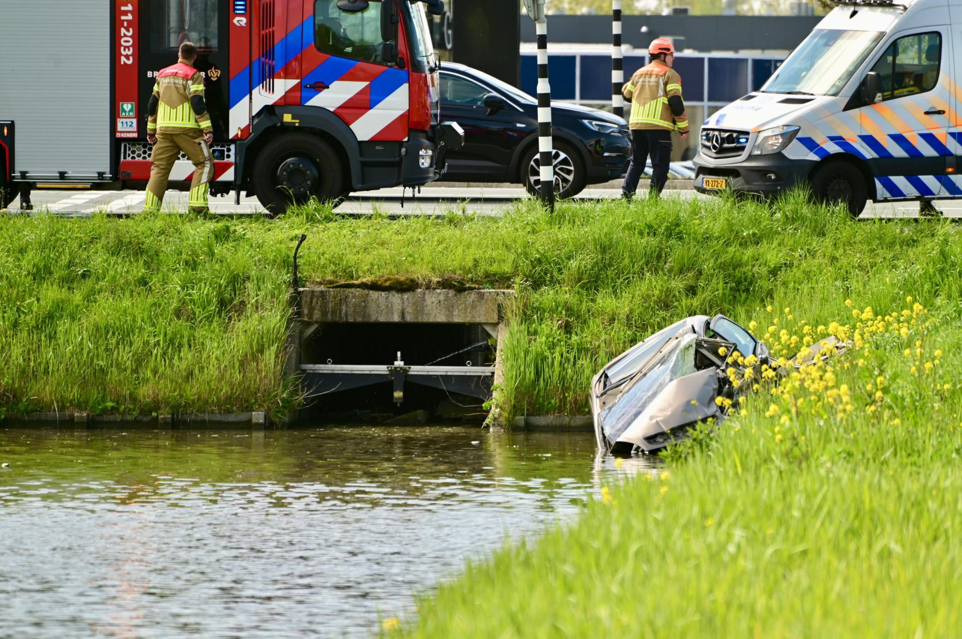 Man rijdt met auto water in en wordt gered door hulpdiensten