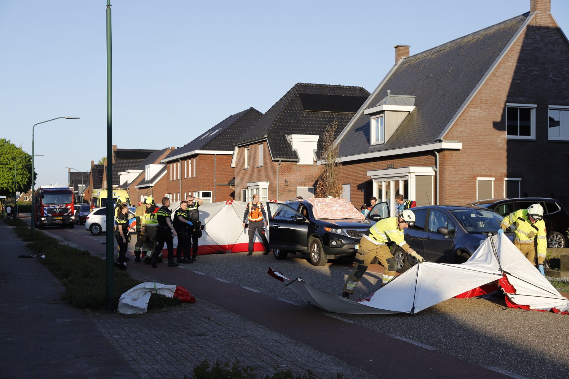 Auto met kapotte ramen afgedekt, politie met zware vesten aanwezig