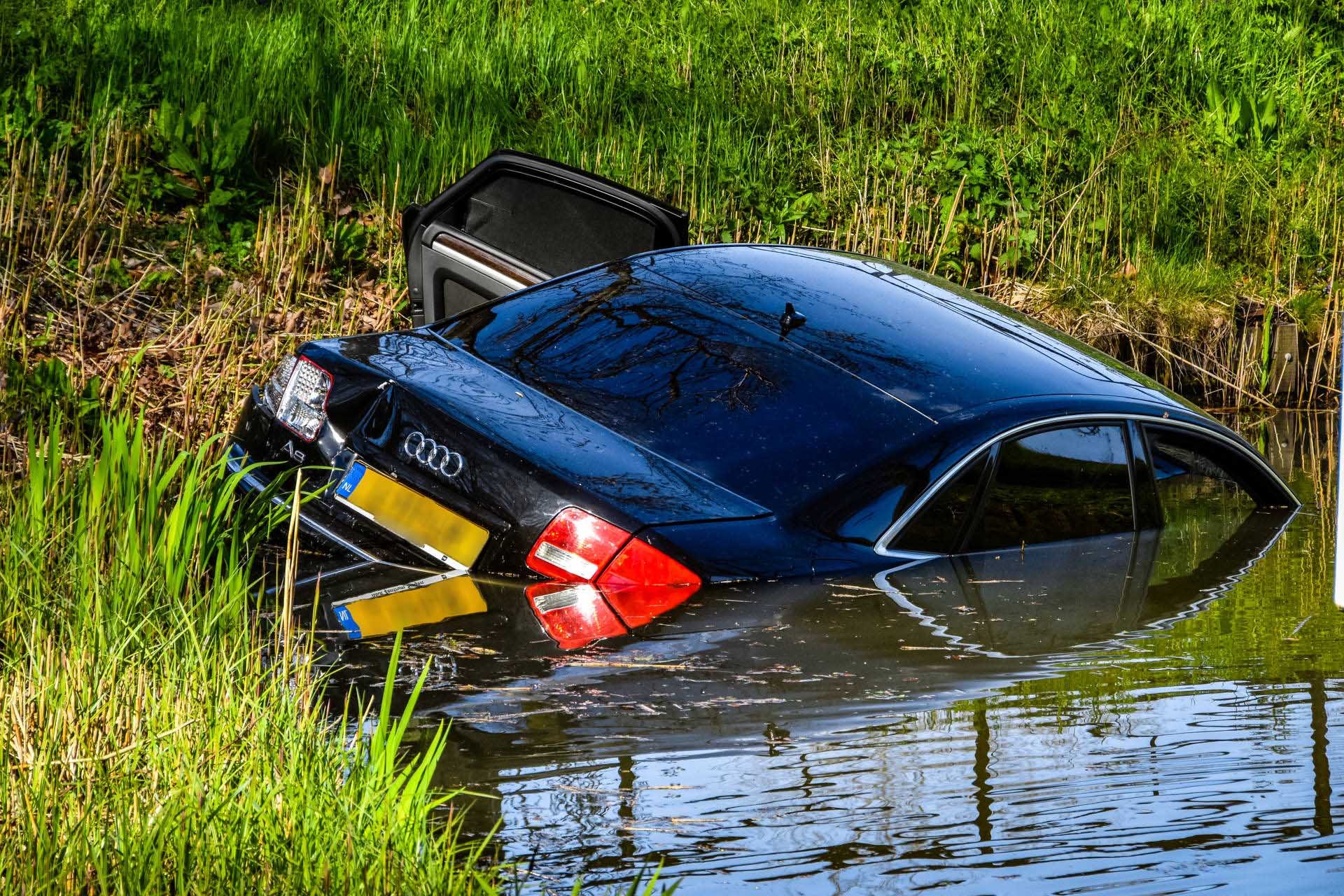 Auto rijdt sloot in na botsing; bestuurder aangehouden