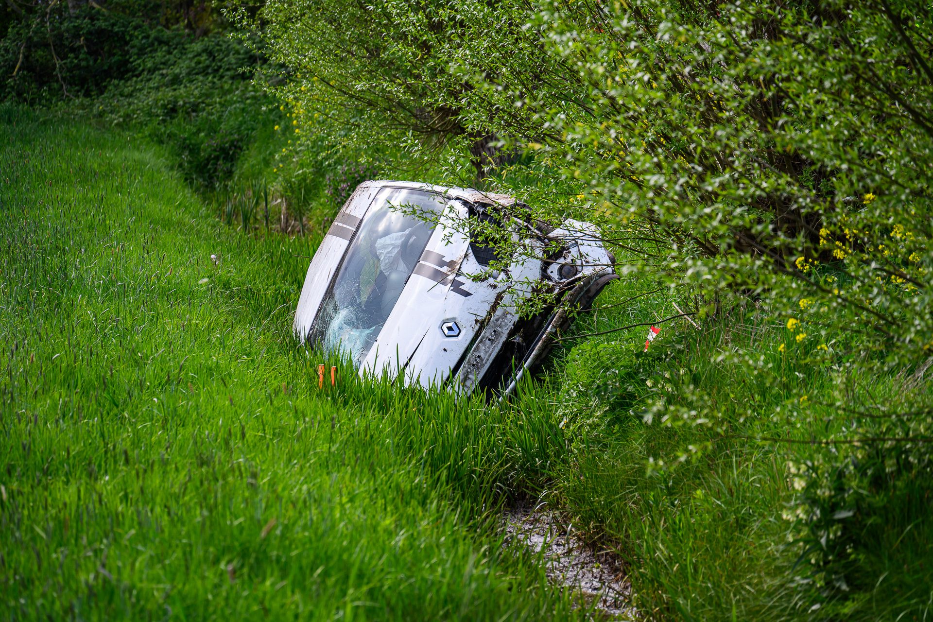 Auto raakt van weg en belandt op zijkant in sloot