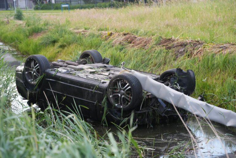 Auto crasht in sloot na botsing met andere auto