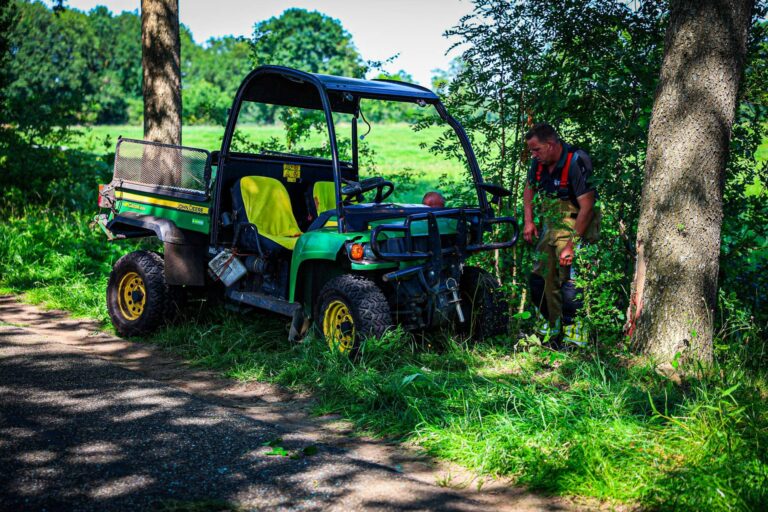 Inzittende bekneld na botsing tegen boom