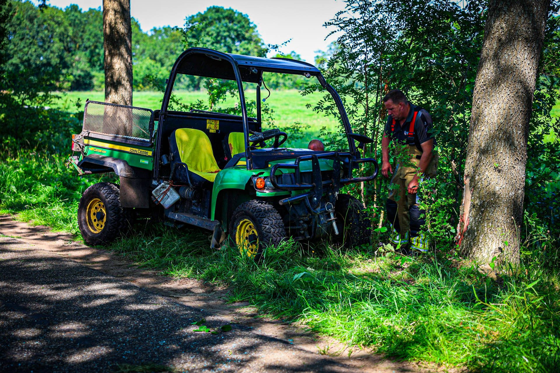 Inzittende bekneld na botsing tegen boom