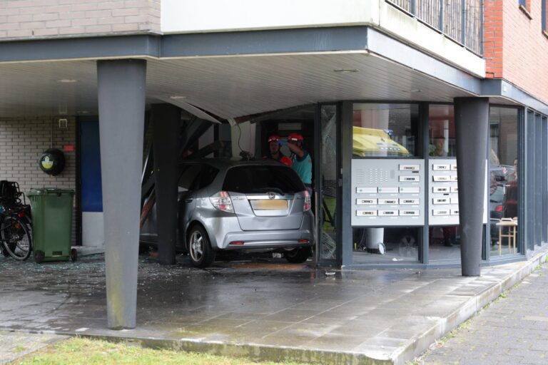 Auto eindigt in portiek van flatgebouw