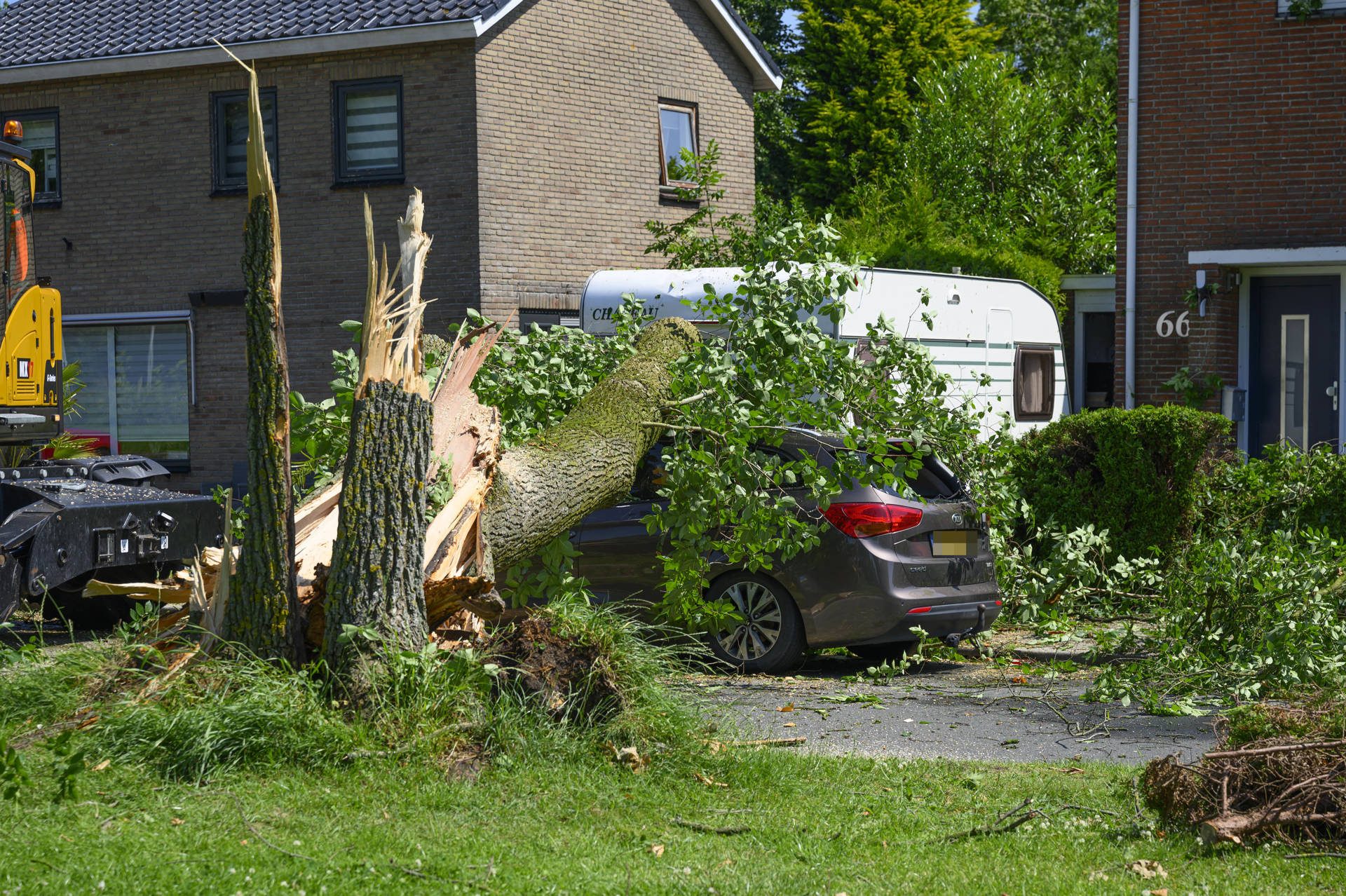 Boom valt op auto en caravan na noodweer