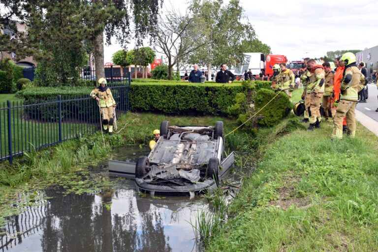 Auto op zijn kop in sloot na botsing met lantaarnpaal