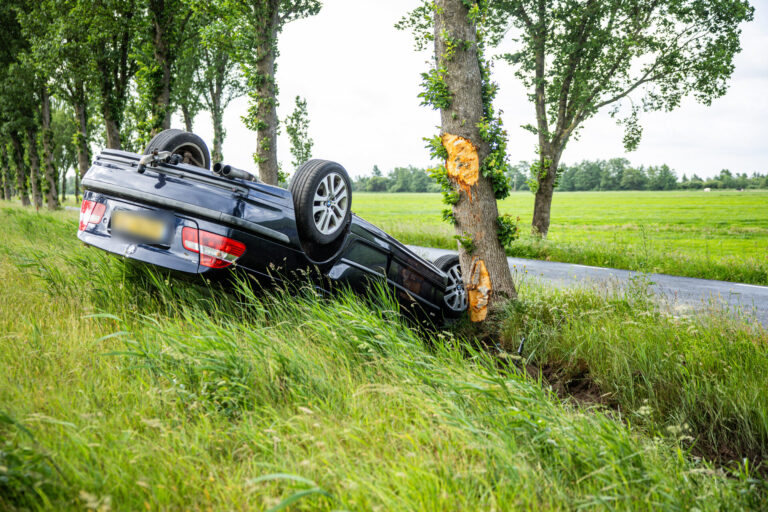 Bestuurder gewond na botsing tegen boom en auto over de kop