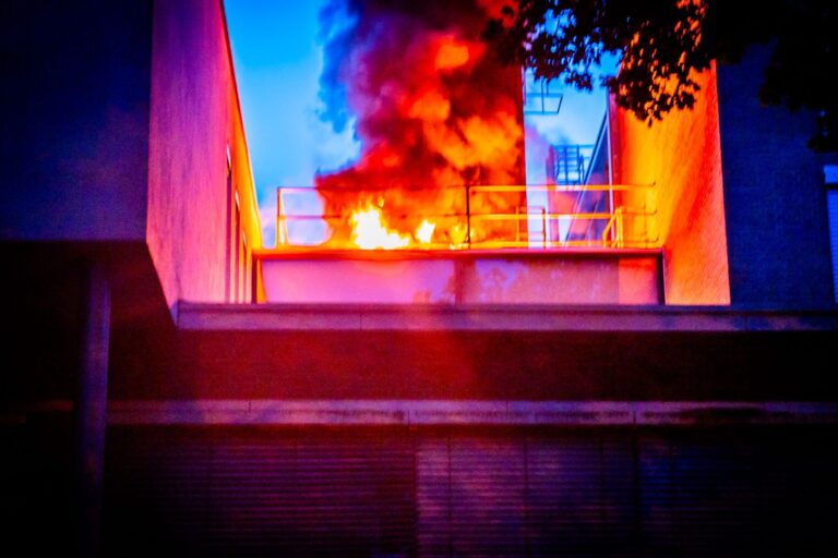 Brand op dak van school, grote rookpluim door brandende zonnepanelen